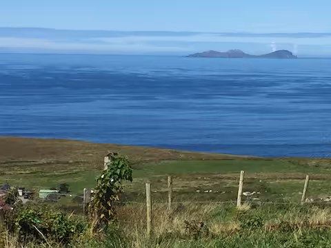 Green coastal landscape on Valentia Island with a view of the Skelligs